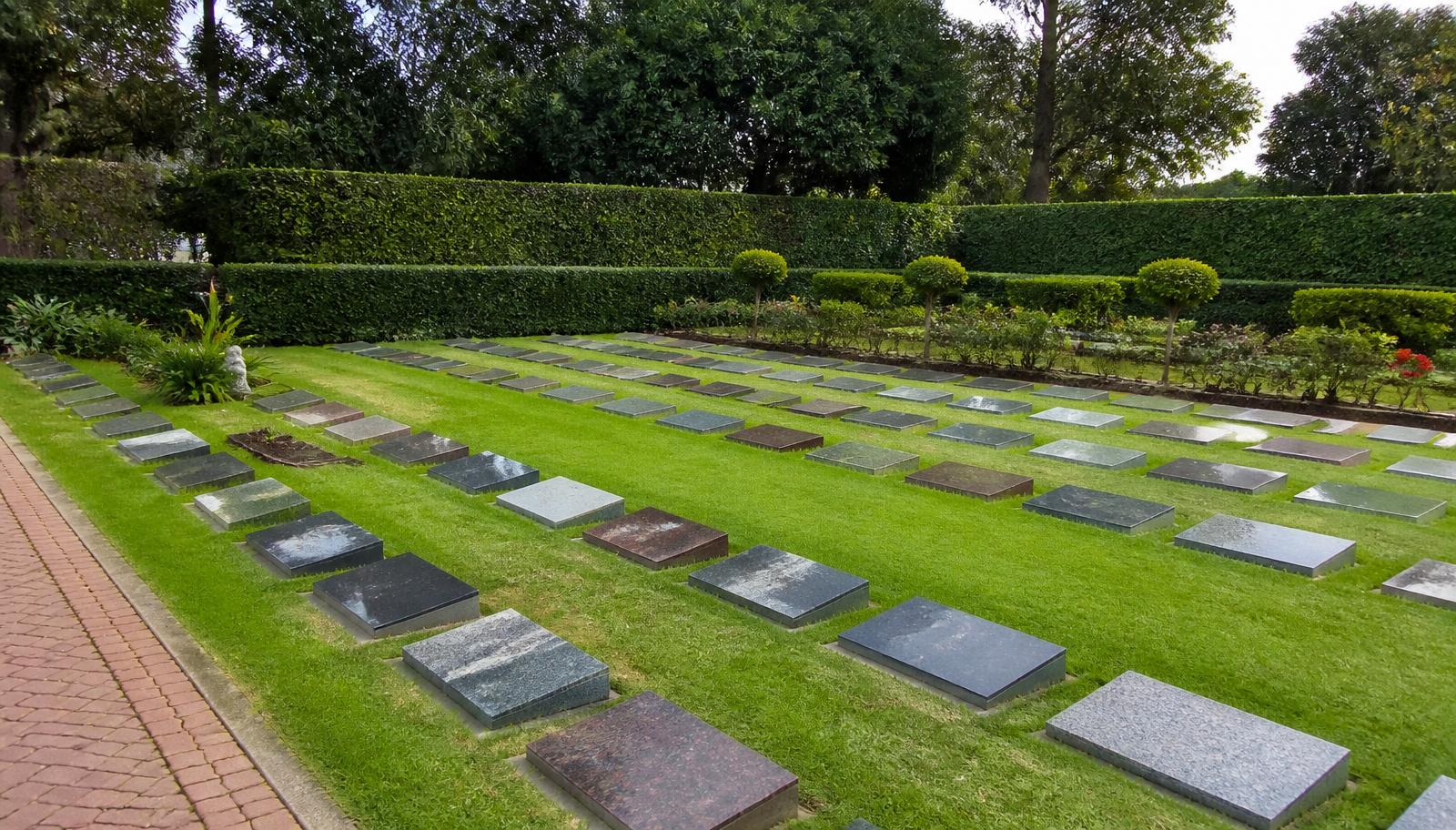 Rows of polished granite memorial plaques set in a mown lawn burial garden