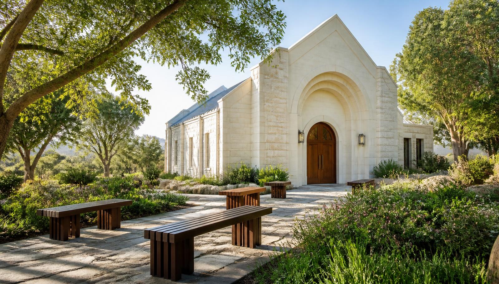 Stone memorial chapel exterior with timber doors and garden benches